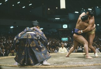 JAPAN, Honshu, Tokyo, Grand Sumo wrestling match with referee in ritual dress