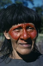 ECUADOR, Amazon, People, Portrait of Auca Indian with red face paint from achole plant.