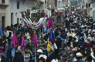 ECUADOR, Imbabura, Cotacachi, Easter procession through narrow street lined with spectators.