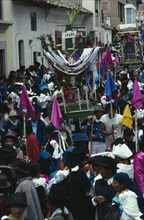 ECUADOR, Imbabura, Cotacachi, Easter procession through narrow street lined with spectators.
