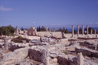 CYPRUS, Kourion, Sanctuary of Apollo Hylates and tourists with sea beyond.