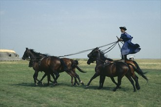 HUNGARY, Great Hungarian Plain, Cossack horseman driving team of five horses from sanding position
