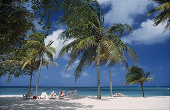 CUBA, Holguin, Guardalevaca, Guardalevaca beach with sunbathers among palm trees
