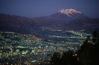 20054568 BOLIVIA  La Paz Illuminated cityscape and snow capped peak of Mount Illimani at dusk.