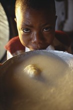 TANZANIA			, "				", Singida, Young boy next to bowl of breakfast at the Kititimo Centre School for