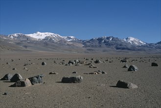 BOLIVIA, Altiplano, Potosi, Salar de Uyuni.  Desert landscape scattered with rocks near Laguna
