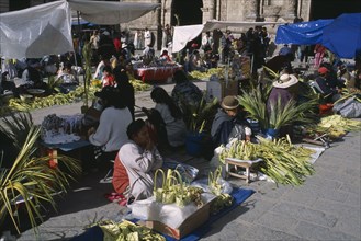 BOLIVIA, La Paz, Women selling woven palm baskets and palm fronds outside San Francisco church for