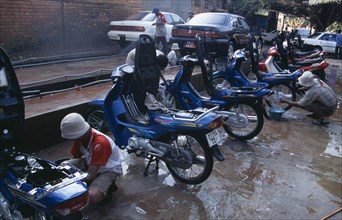 CAMBODIA, Siem Reap, Motorbikes and cars having the local fine red dust washed of them