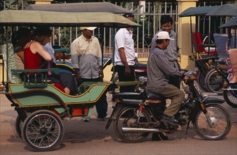 CAMBODIA, Siem Reap, Two female tourists sitting in a stationary tuk tuk