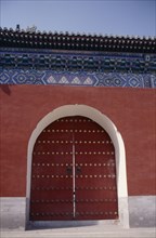 CHINA, Beijing, Temple of Heaven.  Detail of gateway set into red painted wall with decorative blue