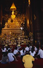 THAILAND, South, Bangkok, Wat Pho main prayer hall with a group of Thai students and teacher seated