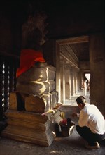 CAMBODIA, Siem Reap Province, Angkor Wat, Interior of shrine on the upper level with visitor