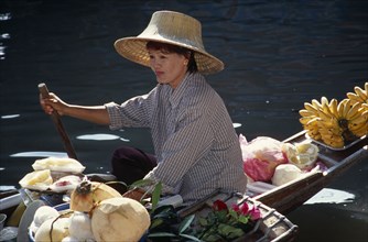 THAILAND, South, Bangkok, Damnoen Saduak Floating Market female fruit vendors in her canoe