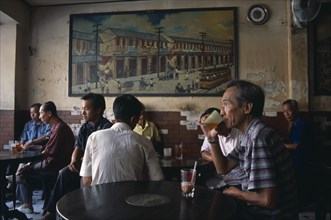 THAILAND, South, Bangkok, Chinatown teahouse with male locals seated in front of an old painting of