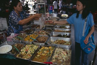 THAILAND, South, Bangkok, Woman selling cooked food to a local woman in an alley beside Patpong 1