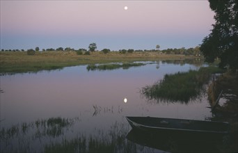 BOTSWANA, River Chobe, Full moon reflected in the river at dusk.