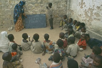 SOMALIA, Baidoa, Teacher with pupils in outdoor classroom at school in Baidoa orphanage.