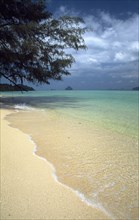 THAILAND, Krabi, Koh Lanta Marine NP, Koh Rok shoreline with gentle waves below overhanging