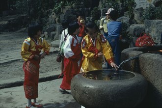 SOUTH KOREA, People, Children, Children in national dress at a well in a Buddhist temple.
