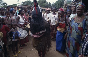 SIERRA LEONE, Kambla, Female initiation ceremony with masked initiate amongst a group of women and