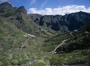 SPAIN, Canary Islands, Tenerife, Masca.  Winding road through valley with housing on terraced lower
