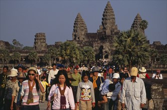 CAMBODIA, Siem Reap Province, Angkor Wat, Tourists on stone causeway leading to temple complex.