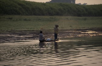 BRAZIL, Amazon Basin, Transport, Fishermen in canoe throwing out net.