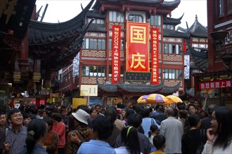 CHINA, Shanghai, Crowded street scene with red and black traditional architecture