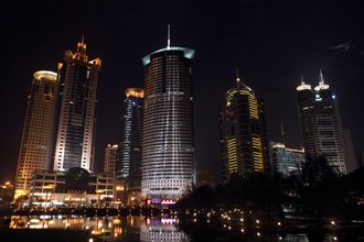 CHINA, Shanghai, Waterfront city skyline with skyscrapers illuminated at night