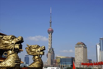 CHINA, Shanghai, City skyline and Television Tower with golden dragon head statues in the
