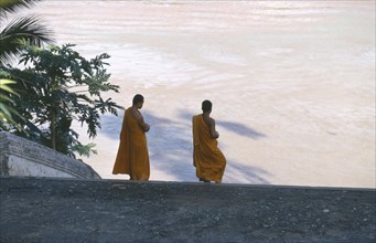 LAOS, Religion, Buddhism, Two monks on steps leading down to river.