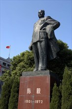 CHINA, Shanghai, The Bund. Statue of Mao against a backdrop of formal bushes and a flag fly from
