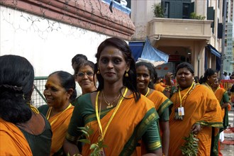 SINGAPORE, , Group of women in orange and green saris gathered at an Indian Temple