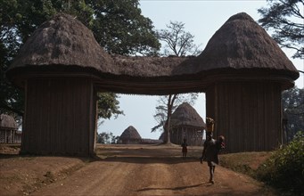CAMEROON, Bafut, Thatched gateway with woman and children below.