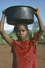 CONGO, Tribal Peoples, Young girl carrying water vessel on her head.
