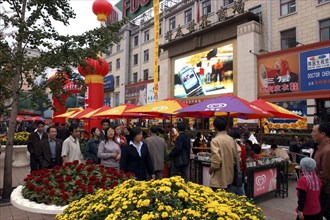CHINA, Beijing, Colourful market stall in modern shopping street with passing shoppers