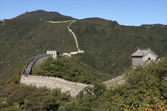 CHINA, Great Wall, View over a section of the wall which leads through the green hilly landscape