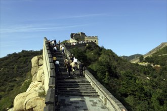 CHINA, Great Wall, View along a section of the wall with tourists walking up steps