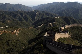 CHINA, Great Wall, View over a section of the wall which leads through the green hilly landscape