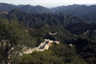CHINA, Great Wall, View over a section of the wall which leads through the green hilly landscape