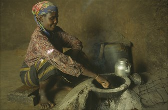 KENYA, West Pokot, Kaprontin Village, Woman cooking on a locally made energy saving stove