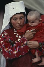 AFGHANISTAN, People, Portrait of Kirghiz woman holding baby.
