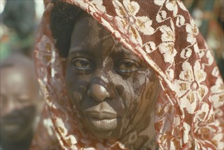 NIGERIA, North East, Maiduguri, Portrait of Kanuri Arab woman with sun through head dress casting