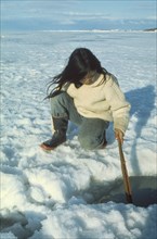 CANADA, North West Territories, Frobisher Bay, Innuit girl ice fishing