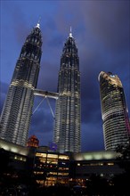 MALAYSIA, Kuala Lumpur, Angled view looking up at the Petronas Twin Towers illuminated at night