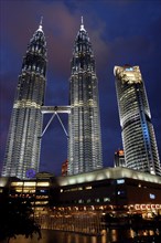 MALAYSIA, Kuala Lumpur, Angled view looking up at the Petronas Twin Towers illuminated at night