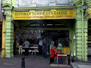 MALAYSIA, Kuala Lumpur, Curry shop front with two women wearing red aprons standing outside