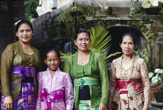 INDONESIA, Bali, Ubud, Family group of women and young girl on way to temple.