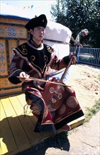 MONGOLIA, Ulaanbaatar, Khumii throat singer with a morin khuur horsehead fiddle.