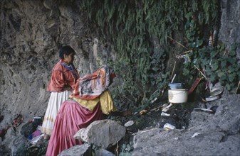MEXICO, San Luis Potosi State, Sierra de Catorce, Huichol Indian women placing offerings at sacred
